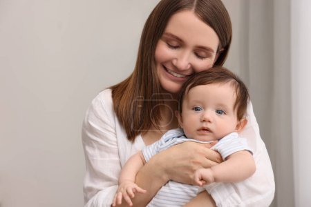 Glückliche Mutter mit ihrem kleinen Baby im Haus