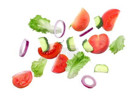Lettuce leaves, cut cucumber, onion and tomatoes falling on white background