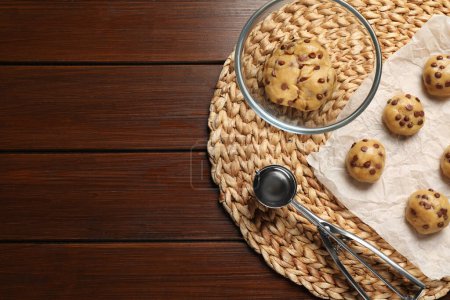 Téléchargez les photos : Pâte fraîche et biscuits aux pépites de chocolat non cuits sur table en bois, vue de dessus. Espace pour le texte - en image libre de droit