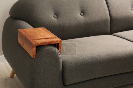 Photo for Wooden armrest table on sofa in room. Interior element - Royalty Free Image