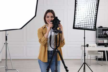 Téléchargez les photos : Photographe professionnel travaillant avec un appareil photo dans un studio photo moderne - en image libre de droit