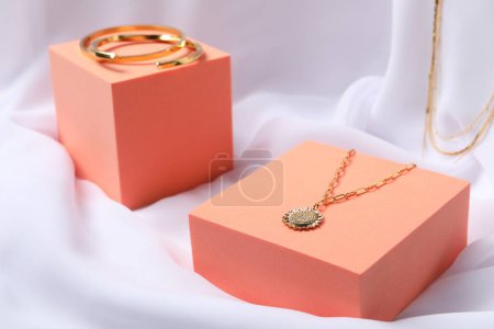 Stylish presentation of bracelets and necklace on white cloth