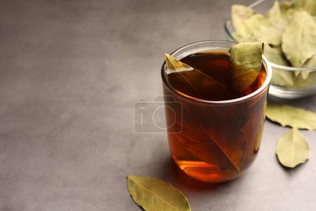 Téléchargez les photos : Tasse de thé fraîchement infusé avec des feuilles de laurier sur table grise. Espace pour le texte - en image libre de droit