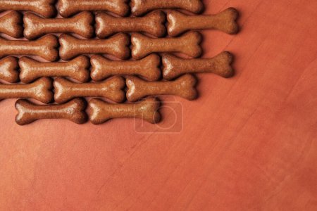 Téléchargez les photos : Biscuits pour chiens en forme d'os sur fond en bois, pose plate. Espace pour le texte - en image libre de droit