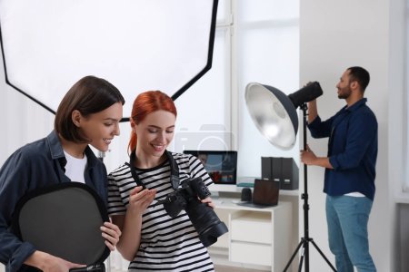 Téléchargez les photos : Jeunes photographes professionnels travaillant dans un studio photo moderne - en image libre de droit