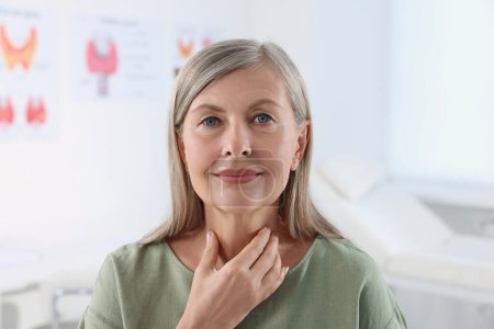 Téléchargez les photos : Système endocrinien. Femme âgée faisant l'auto-examen thyroïdien à l'intérieur - en image libre de droit