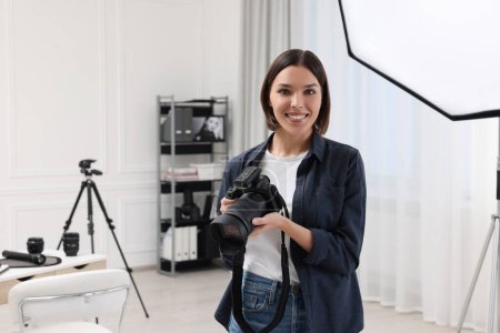 Téléchargez les photos : Jeune photographe professionnel avec appareil photo en studio photo, espace pour le texte - en image libre de droit