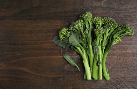 Foto de Broccolini fresco crudo sobre mesa de madera, plano y espacio para el texto. Alimento saludable - Imagen libre de derechos