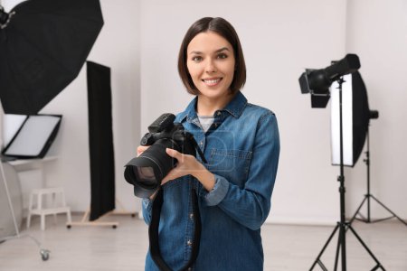 Photo for Professional photographer with camera in modern photo studio - Royalty Free Image