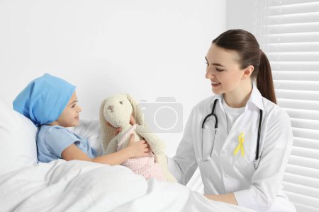 Childhood cancer. Doctor and little patient with toy bunny in hospital
