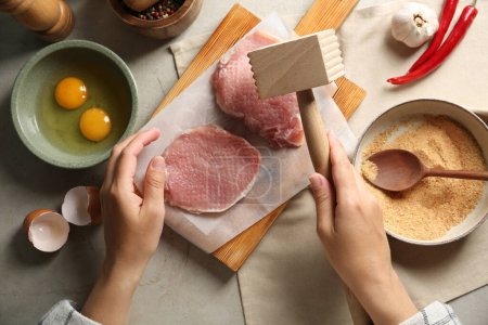Téléchargez les photos : Schnitzel de cuisine femme à table grise, vue de dessus - en image libre de droit