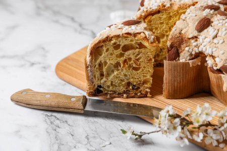 Foto de Delicioso pastel de paloma de Pascua italiana (Colomba di Pasqua tradicional) y cuchillo en la mesa blanca, primer plano - Imagen libre de derechos