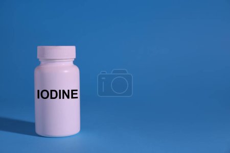 Foto de Envase de plástico de yodo médico sobre fondo azul claro, espacio para texto - Imagen libre de derechos