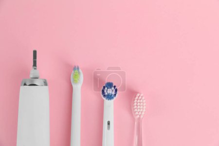Photo for Electric toothbrush and replacement brush heads on pink background, flat lay. Space for text - Royalty Free Image