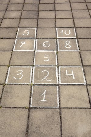 Photo for Hopscotch drawn with white chalk on street tiles outdoors - Royalty Free Image