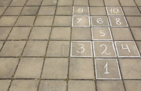 Photo for Hopscotch drawn with white chalk on street tiles outdoors. Space for text - Royalty Free Image