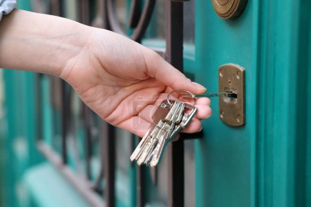 Frau öffnet Tür mit Schlüssel im Freien, Nahaufnahme