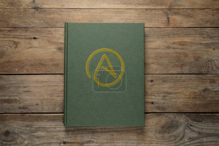 Foto de Libro con el símbolo del ateísmo sobre fondo de madera, vista superior - Imagen libre de derechos