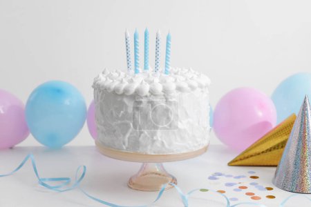 Foto de Delicioso pastel con velas y decoraciones en mesa blanca - Imagen libre de derechos