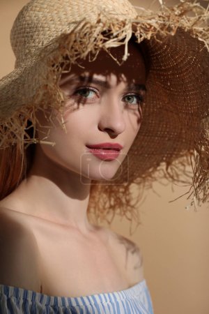 Téléchargez les photos : Belle jeune femme au soleil sur fond beige - en image libre de droit