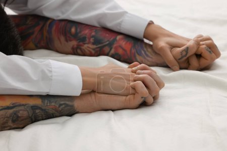 Photo for Passionate couple having sex on bed, closeup of hands - Royalty Free Image