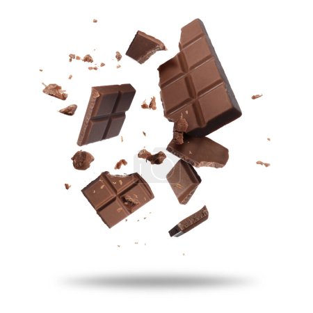 Broken chocolate bar pieces falling on white background