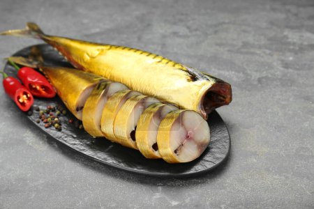 Foto de Delicious smoked mackerels with pepper, dill and spices on dark grey table - Imagen libre de derechos