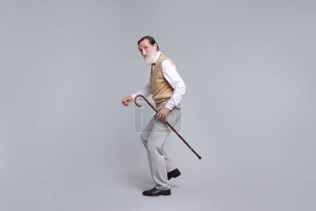 Photo for Senior man with walking cane on light gray background - Royalty Free Image