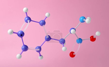 Molecule of phenylalanine on pink background. Chemical model