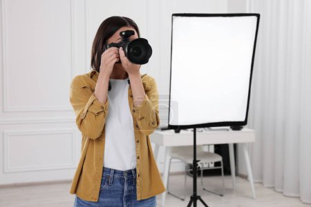 Téléchargez les photos : Photographe professionnel prenant des photos dans un studio photo moderne, espace pour le texte - en image libre de droit