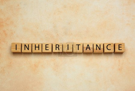 Word Inheritance made with wooden cubes on beige background, flat lay