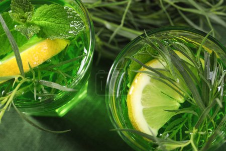 Photo for Glasses of refreshing tarragon drink with lemon slices on table, flat lay - Royalty Free Image