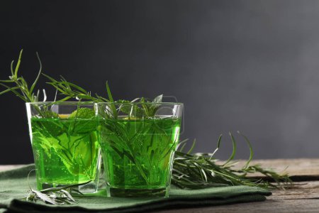 Photo for Glasses of refreshing tarragon drink on wooden table. Space for text - Royalty Free Image