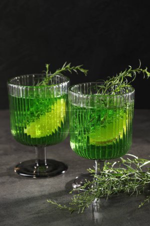 Photo for Glasses of homemade refreshing tarragon drink and sprigs on grey table - Royalty Free Image