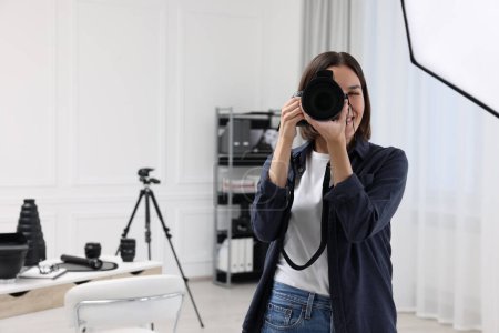 Téléchargez les photos : Jeune photographe professionnel prenant des photos en studio photo, espace pour le texte - en image libre de droit