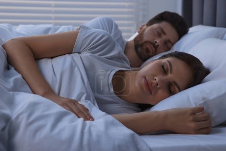 Téléchargez les photos : Charmant couple dormant ensemble au lit la nuit - en image libre de droit