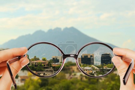 Foto de Corrección de visión. Mujer mirando a través de gafas y viendo el paisaje más claro - Imagen libre de derechos