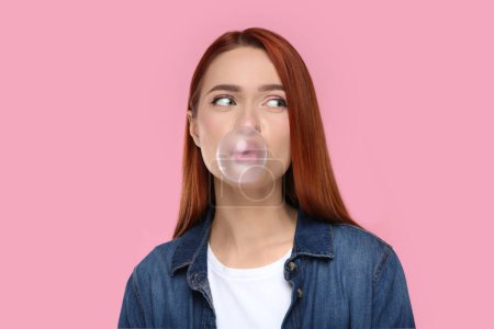 Photo for Portrait of beautiful woman blowing bubble gum on pink background - Royalty Free Image