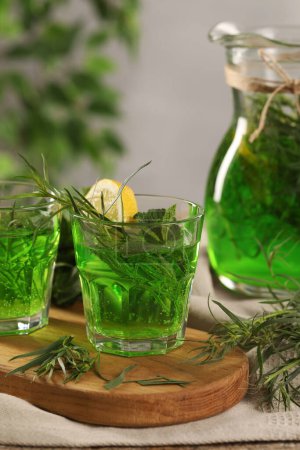 Photo for Refreshing tarragon drink with lemon slices on table - Royalty Free Image