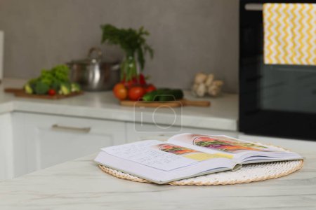 Foto de Libro de recetas sobre mesa de mármol blanco en la cocina, primer plano. Espacio para texto - Imagen libre de derechos