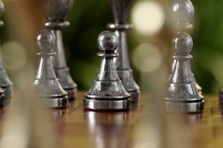 Photo for Silver pawns on chess board against blurred background, closeup - Royalty Free Image