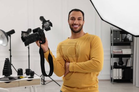 Téléchargez les photos : Jeune photographe professionnel avec appareil photo dans un studio photo moderne - en image libre de droit