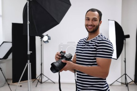 Téléchargez les photos : Photographe professionnel avec appareil photo dans un studio photo moderne, espace pour le texte - en image libre de droit