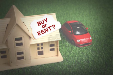Photo for Model of house with card Buy Or Rent near toy car on green grass - Royalty Free Image