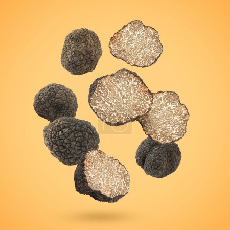 Photo for Cut and whole truffles falling on golden background - Royalty Free Image