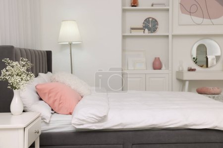 Photo for Stylish bedroom interior with comfortable bed, nightstand and lamp - Royalty Free Image