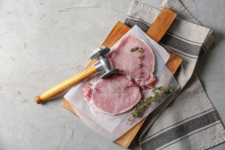 Téléchargez les photos : Schnitzel de cuisine. Côtelettes de porc crues, maillet thym et viande sur table grise, vue du dessus avec espace pour le texte - en image libre de droit
