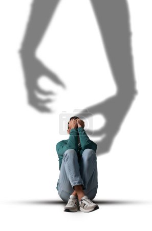 Photo for Suffering from hallucinations. Scared man closing eyes because of shadow of monster hands reaching to him - Royalty Free Image