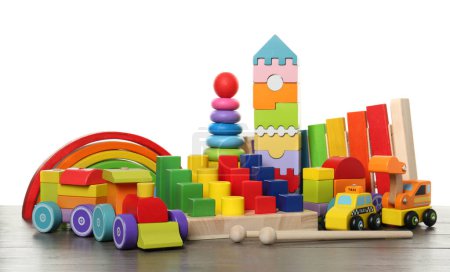 Téléchargez les photos : Différents jouets pour enfants sur une table en bois sur fond blanc - en image libre de droit