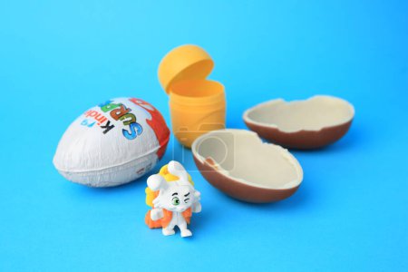 Photo for Slynchev Bryag, Bulgaria - May 25, 2023: Kinder Surprise Eggs, plastic capsule and toy bunny on light blue background - Royalty Free Image
